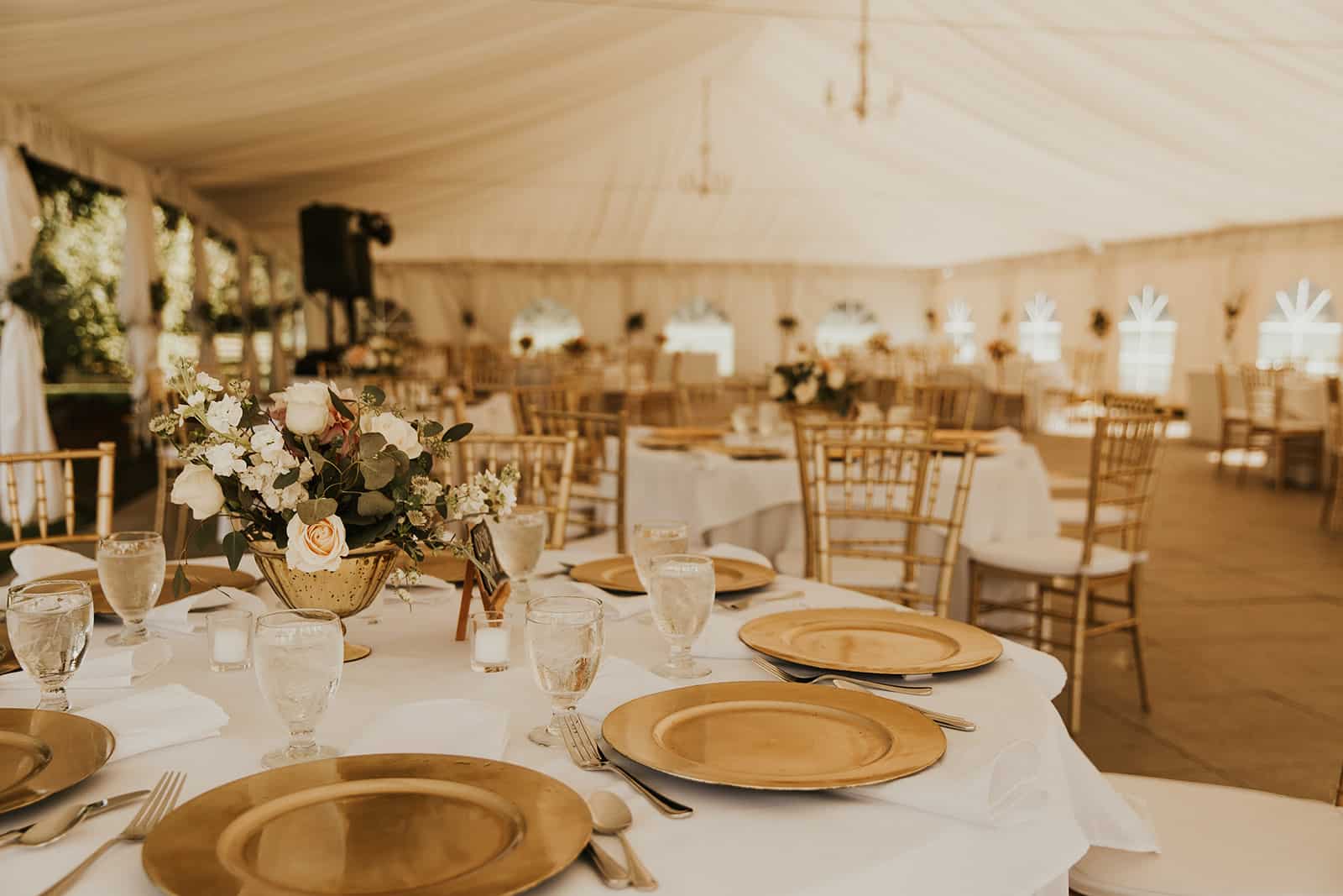 outdoor wedding tent, wedding tent decor, classic wedding centerpiece, romantic wedding centerpiece, vintage wedding centerpiece, reception tables, reception guest table decor, gold and white wedding, gold and ivory wedding, cream colored flowers