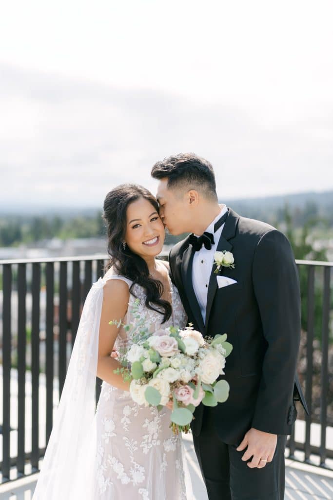 bride and groom carrying a soft romantic bridal bouquet in blush and white flowers at Ironlight wedding venue in Lake Oswego