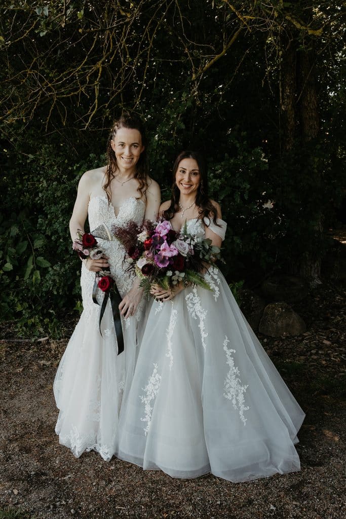 Brides holding moody bridal bouquets at an enchanted forest wedding at the Aerie Eagles Landing in Portland, Oregon