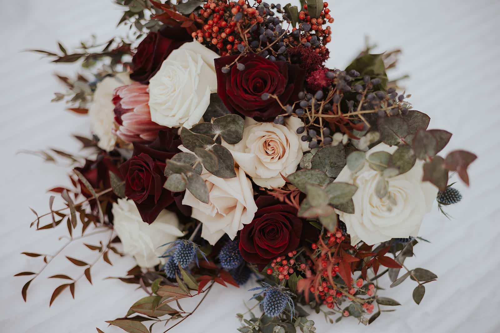 winter bridal bouquet on the snow in Oregon, designed by Portland wedding florist Flowers by Alana