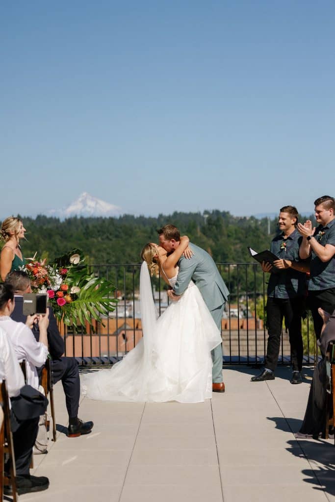 bride and groom kiss at their modern tropical wedding ceremony at ironlight in lake oswego near portland